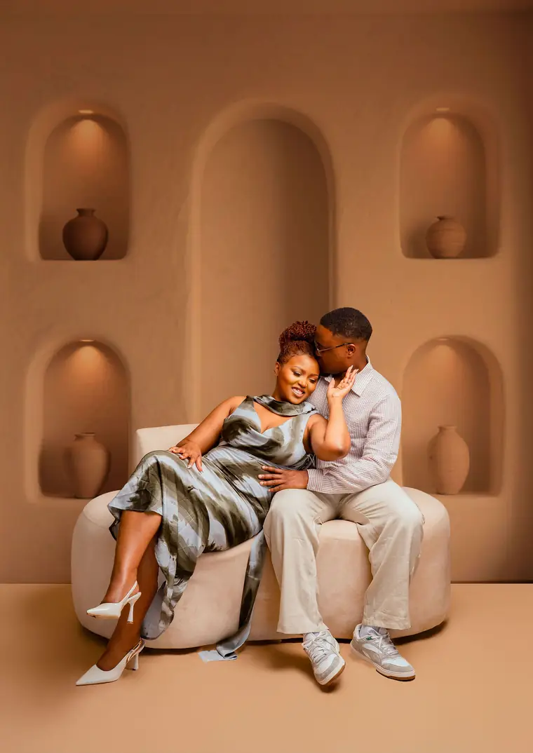 A couple relaxing on a cream sofa in front of arched alcoves
