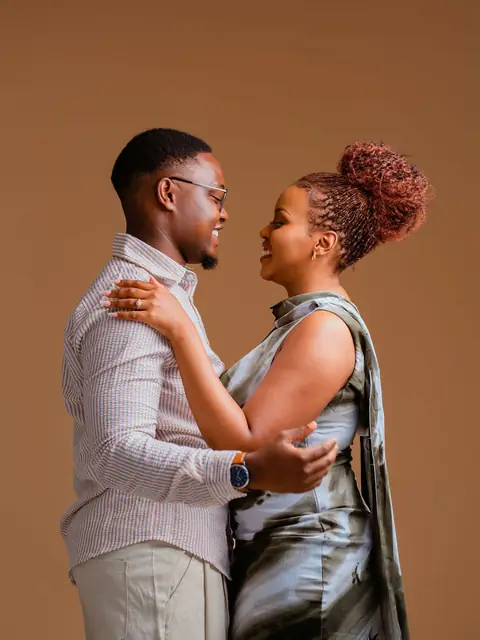 A couple embracing in a warm studio pre-wedding shoot