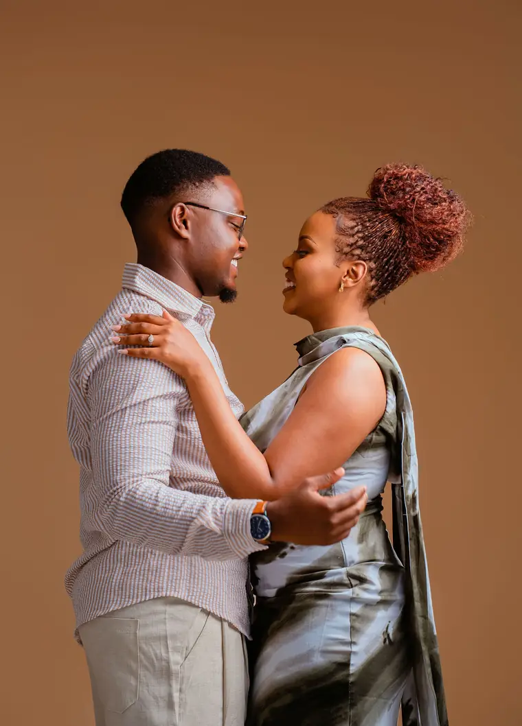 A couple embracing in a warm studio pre-wedding shoot