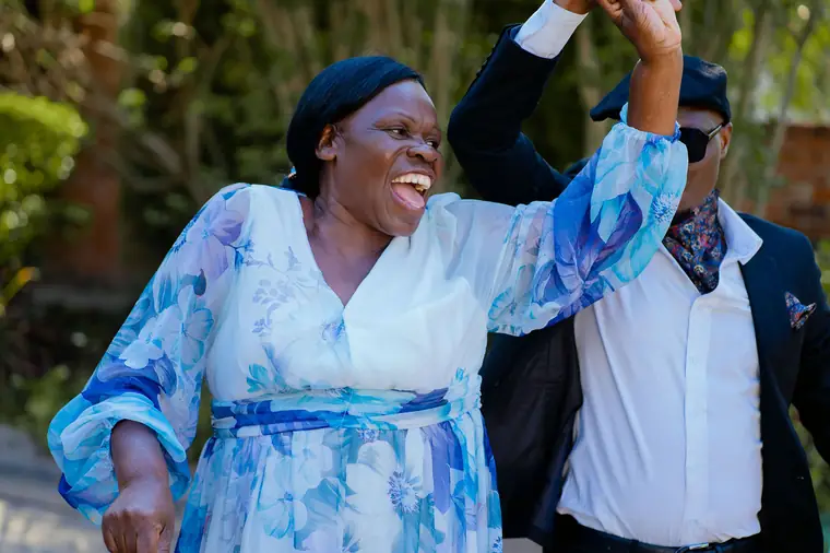 A guest dancing with her arms raised at a roora