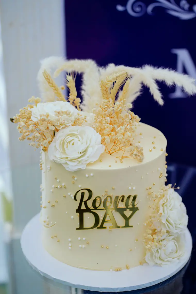A cream cake with a gold Roora Day topper