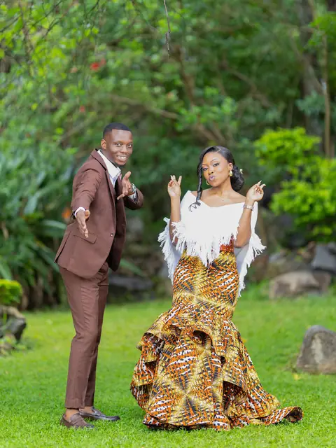 A couple striking a playful pose in a garden at their roora