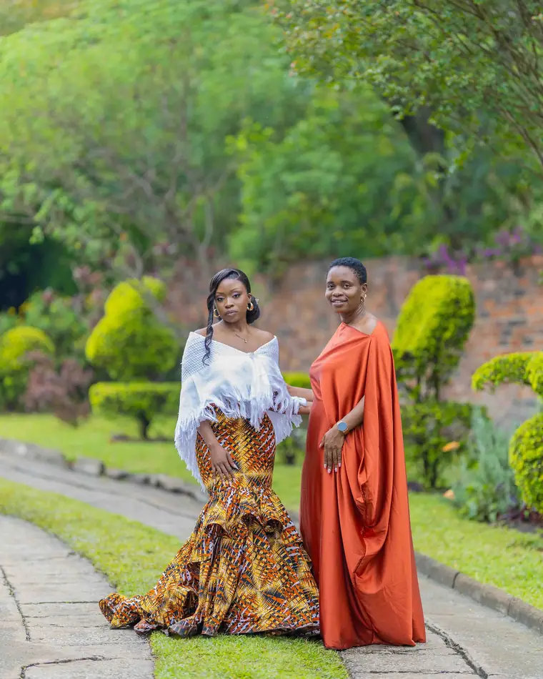 A bride in African print beside a friend in a rust gown