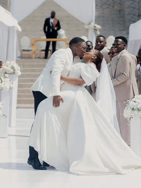 A groom dips his bride for a kiss at the end of the aisle