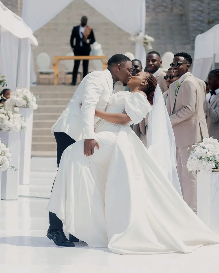 A groom dips his bride for a kiss at the end of the aisle