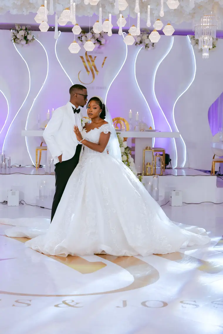 A couple holding each other on a lit dance floor